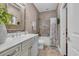 Well-lit bathroom with a marble countertop, decorative mirror, and tiled shower-tub combo at 124 Turtle Creek Dr., Pawleys Island, SC 29585