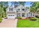 Charming two-story home with a well-manicured lawn, beautiful landscaping, and a welcoming front porch at 124 Turtle Creek Dr., Pawleys Island, SC 29585