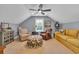 Comfortable sitting area with neutral armchairs, butterfly ottoman, and a yellow couch under a ceiling fan at 124 Turtle Creek Dr., Pawleys Island, SC 29585