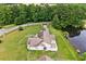 Aerial shot of home with lush yard by pond and surrounded by mature trees at 131 Pine Lake Circle, Ocean Isle Beach, NC 28469
