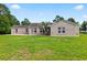 A lush green lawn in backyard of house, with palm tree accenting the rear elevation at 131 Pine Lake Circle, Ocean Isle Beach, NC 28469