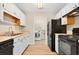 Functional kitchen featuring white cabinets, laminate countertops, and black appliances with a laundry area at 131 Pine Lake Circle, Ocean Isle Beach, NC 28469