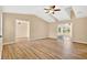 Bright living room featuring wood floors, ceiling fan, and a vaulted ceiling with access to the patio at 131 Pine Lake Circle, Ocean Isle Beach, NC 28469