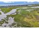 Sprawling aerial view of a coastal community highlights the marshland, waterway, and the distant coastline and community at 140 South Cove Pl. # 6C, Pawleys Island, SC 29585
