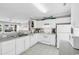 Bright kitchen featuring white appliances, cabinets, tile floors, and a partial view into the living space at 140 South Cove Pl. # 6C, Pawleys Island, SC 29585