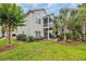 Charming home featuring a backyard with a patio, balcony, and lush tropical landscaping at 1413 Cottage Cove Circle, North Myrtle Beach, SC 29582