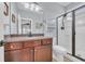 Well-lit bathroom with a dark wood vanity, framed mirror, and glass-enclosed shower at 1413 Cottage Cove Circle, North Myrtle Beach, SC 29582