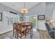 Cozy dining room with a round wooden table, six chairs, and sliding doors to the outside at 1413 Cottage Cove Circle, North Myrtle Beach, SC 29582