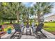 Cozy backyard patio with seating area surrounded by palm trees and lush green landscaping at 1413 Cottage Cove Circle, North Myrtle Beach, SC 29582