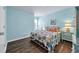 Bedroom featuring stylish coastal decor, beach themed bedding, wood-look flooring, and bright blue walls at 1520 Jardine Loop, Little River, SC 29566