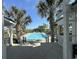 Community swimming pool with lounge seating surrounded by a covered pavilion and palm trees at 1613 James Island Ave., North Myrtle Beach, SC 29582