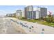 Sweeping beach view featuring white sand and several large condo buildings at 2000 S Ocean Blvd. # V405, Myrtle Beach, SC 29577
