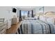 Bright bedroom featuring two beds, TV, dresser, and access to a balcony with views at 2000 S Ocean Blvd. # V405, Myrtle Beach, SC 29577