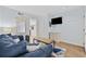 Bright living room with blue sofa, light wood floors, and access to the kitchen area at 2000 S Ocean Blvd. # V405, Myrtle Beach, SC 29577