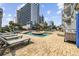 Relaxing pool area surrounded by lounge chairs and tropical palm trees at 2000 S Ocean Blvd. # V405, Myrtle Beach, SC 29577