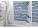 Close up of a bathtub and shower with charming blue and white tiled accent wall at 2001 S Ocean Blvd. # 1408, Myrtle Beach, SC 29577