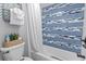 Bathroom featuring toilet, bathtub and shower with charming blue and white tiled accent wall at 2001 S Ocean Blvd. # 1408, Myrtle Beach, SC 29577