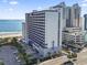 Coastal hotel exterior view with beach, palm trees, pool, and parking at 2001 S Ocean Blvd. # 1408, Myrtle Beach, SC 29577