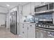 Cozy kitchen features stainless steel appliances, white cabinetry, and blue tile backsplash at 2001 S Ocean Blvd. # 1408, Myrtle Beach, SC 29577