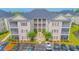 Aerial view of condo complex with manicured landscaping, parking, and pond at 2060 Cross Gate Blvd. # 102, Surfside Beach, SC 29575
