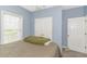 Charming bedroom features light blue walls, plush carpeting, and a view of double door closet space at 2060 Cross Gate Blvd. # 102, Surfside Beach, SC 29575