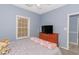 Cozy bedroom with carpet flooring, light blue walls, and a wood dresser with a television at 2060 Cross Gate Blvd. # 102, Surfside Beach, SC 29575