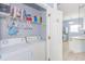 Practical laundry room with washer, dryer, storage shelves, and an open doorway to kitchen at 2060 Cross Gate Blvd. # 102, Surfside Beach, SC 29575