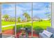 Serene screened patio featuring lush green landscaping and a glimpse of community amenities at 2060 Cross Gate Blvd. # 102, Surfside Beach, SC 29575