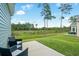 Back patio with comfortable seating and a lush green lawn stretching to the tree line at 228 Averyville Dr., Conway, SC 29526