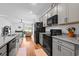 Well-lit kitchen with granite counters, stainless steel appliances, gray cabinets, and hardwood floors at 228 Averyville Dr., Conway, SC 29526