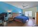 Bright bedroom featuring hardwood floors, ceiling fan, exercise bike, and an accent wall painted in blue at 232 Angel Wing Dr., Myrtle Beach, SC 29588