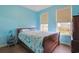 Comfortable bedroom with hardwood floors and a colorful bedspread beneath two sunlit windows at 232 Angel Wing Dr., Myrtle Beach, SC 29588
