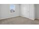 Bedroom featuring neutral carpet, white walls, and a white door leading outside at 24 Cape Point Dr., Conway, SC 29527