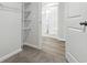 Walk-in closet leading to a bathroom with sliding glass doors and vinyl floors at 24 Cape Point Dr., Conway, SC 29527