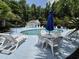 Inviting community pool area featuring comfortable lounge chairs, tables with umbrellas, and lush greenery at 244 Colby Ct., Myrtle Beach, SC 29588