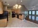 Kitchen area featuring tile flooring, tan cabinets, modern black appliances, and breakfast bar at 244 Colby Ct., Myrtle Beach, SC 29588