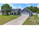 Attractive home with gray siding, a two-car garage, and a long driveway on a sunny day at 250 Penn Circle, Galivants Ferry, SC 29544