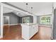 Open-concept living room with kitchen island, stainless appliances, and hardwood floors throughout at 250 Penn Circle, Galivants Ferry, SC 29544