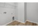 Empty laundry room with wood-look laminate flooring, shelving, and washer/dryer hookups at 28 Cape Point Dr., Conway, SC 29527