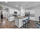 Well-lit kitchen with an island featuring granite countertops, stainless appliances, white cabinets, and modern fixtures at 2882 Ophelia Way, Myrtle Beach, SC 29577
