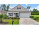 Charming single-story home featuring a well-manicured lawn, a two-car garage, and a welcoming front porch at 308 Firenze Loop, Myrtle Beach, SC 29579