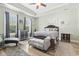 Comfortable main bedroom featuring tray ceilings, two windows, wood flooring, and tasteful decor at 308 Firenze Loop, Myrtle Beach, SC 29579