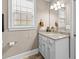 A charming bathroom featuring a granite countertop, white cabinets, and a decorative mirror at 337 St. Julian Ln., Myrtle Beach, SC 29579