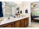 Bathroom featuring a double vanity with wooden cabinets, a large mirror, and serene natural light at 364 Vesta Dr., Myrtle Beach, SC 29579