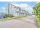 Exterior view of condos with neutral paint and well-maintained landscaping and ample parking at 3700 Golf Colony Lane # 26A, Little River, SC 29566
