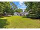 Large, beautifully maintained backyard with lush green grass, mature trees, and patio seating area at 3772 Brown Bark Ln., Murrells Inlet, SC 29576