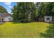 Lush backyard with a well-manicured lawn, mature trees, and a charming white shed at 3772 Brown Bark Ln., Murrells Inlet, SC 29576