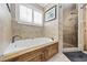 Well-appointed bathroom boasts a relaxing soaking tub, a walk-in shower, and neutral-toned tile at 3772 Brown Bark Ln., Murrells Inlet, SC 29576