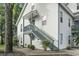 Charming multi-level condo featuring light siding, blue railings, and a private entrance with stairs at 4344 Spa Dr. # 605, Little River, SC 29566