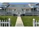 Charming beach house featuring symmetrical design, white picket fence, and well-maintained lawn at 4806 S Ocean Blvd., Surfside Beach, SC 29575